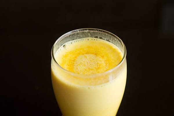 Turmeric milk or gold milk is served in a glass.