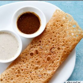 wheat dosa served on a white plate with chutneys in 2 small bowls.