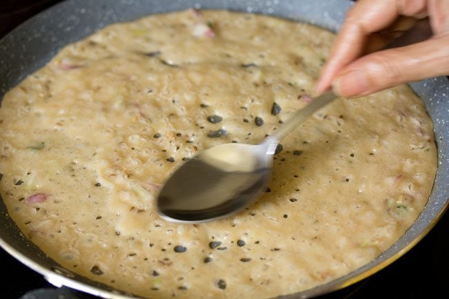 cooking second side of wheat dosa on the pan