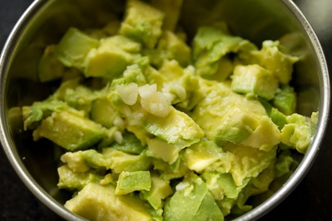 avocado pulp and garlic in a bowl