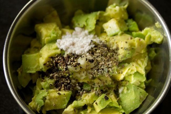 mixing avocado pulp and spices in a bowl