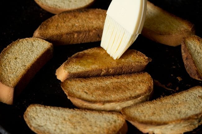 brushing the pieces of garlic bread with olive oil.