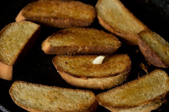 rubbing garlic on bread slices