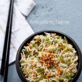 burnt garlic fried rice served in a black bowl with text layover.