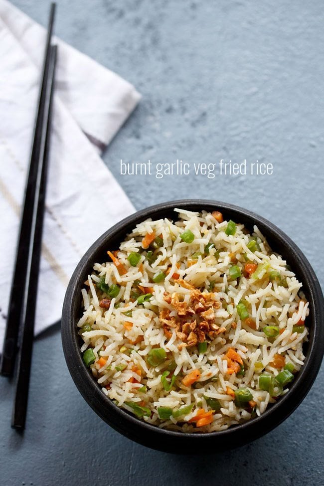 burnt garlic fried rice served in a black bowl with text layover.