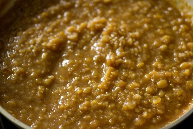 cooking chana dal-jaggery-coconut mixture in a pan on low heat. 