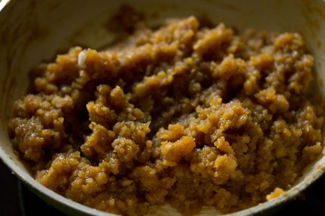 chana dal-jaggery-coconut mixture leaving the sides of the pan. 