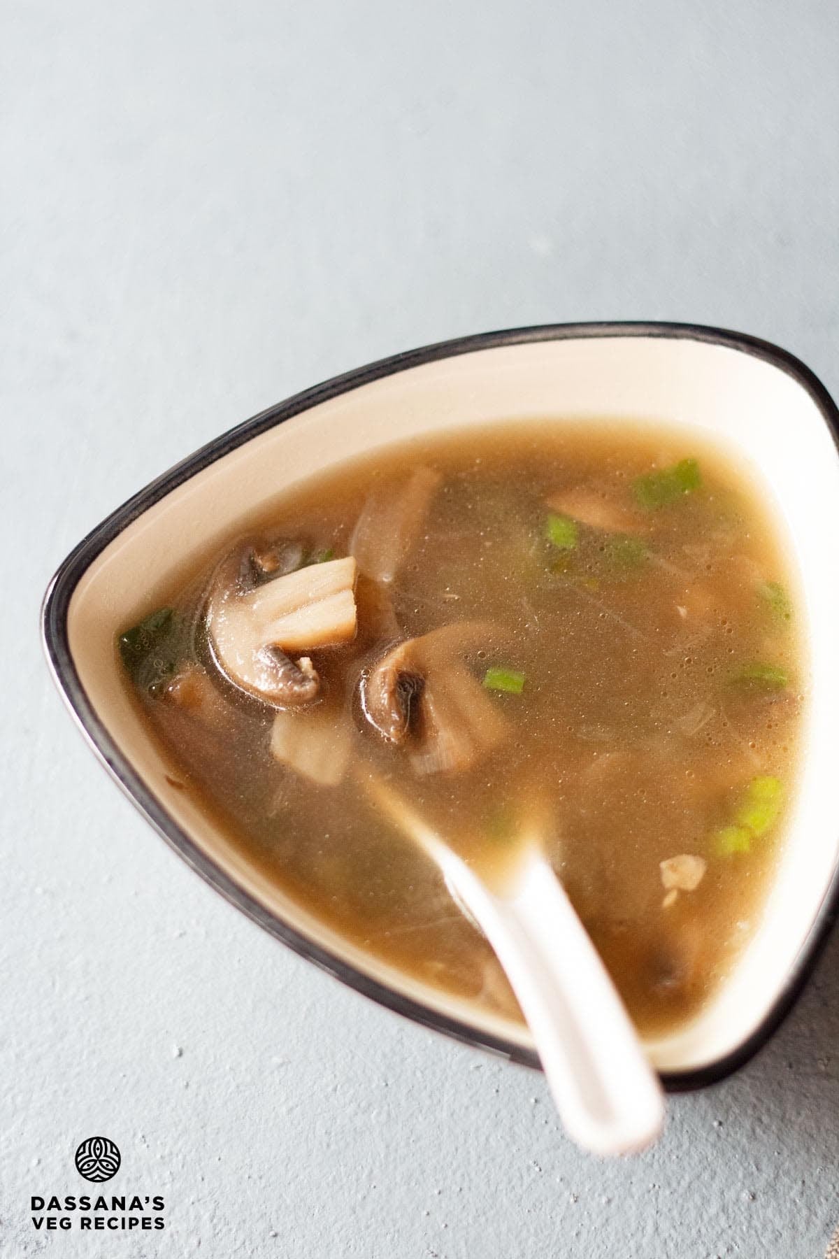 Chinese soup in a ceramic bowl with a spoon.