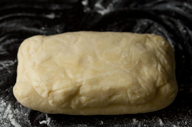 chilled puff pastry dough on a floured work surface.