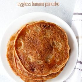 eggless banana pancakes drizzled with maple syrup on a white plate on a white board