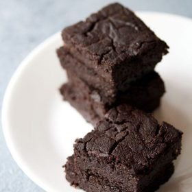 brownie cut into wedges, staked on top of each other and served on a white plate.