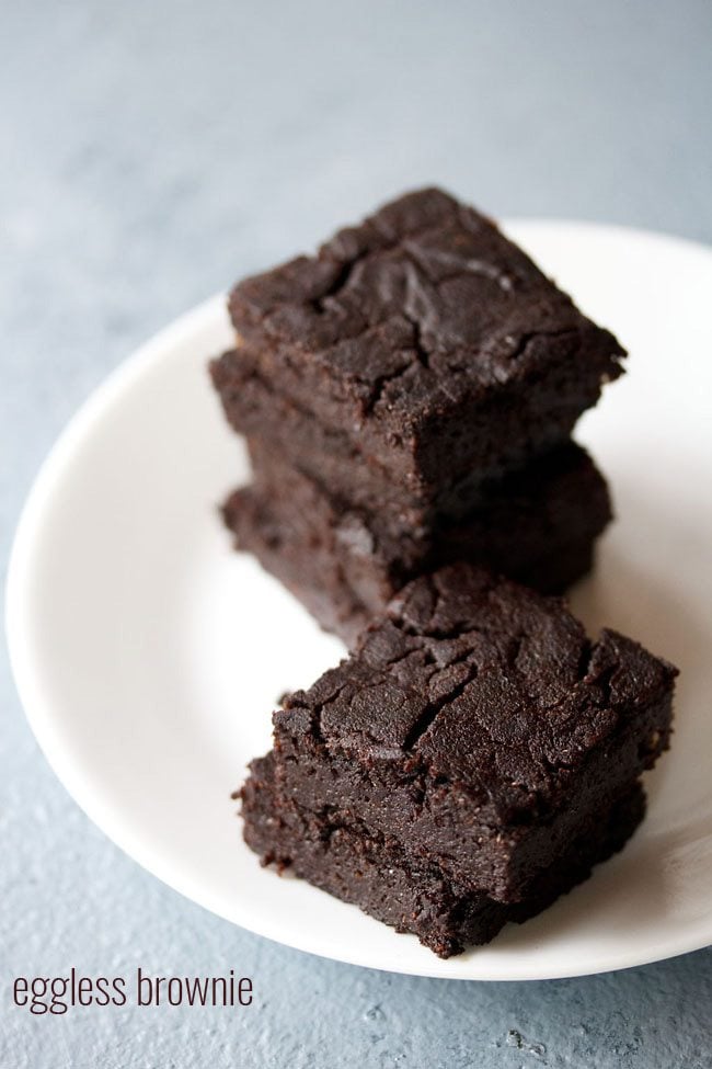 brownie cut into wedges, staked on top of each other and served on a white plate.