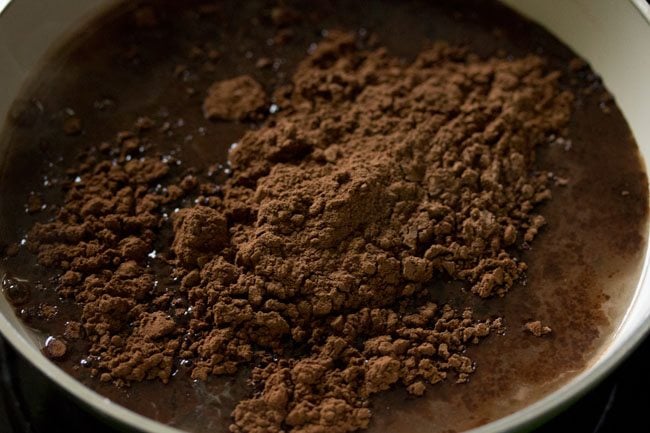 cacao en polvo agregado al agua caliente para hacer una solución de cacao. 