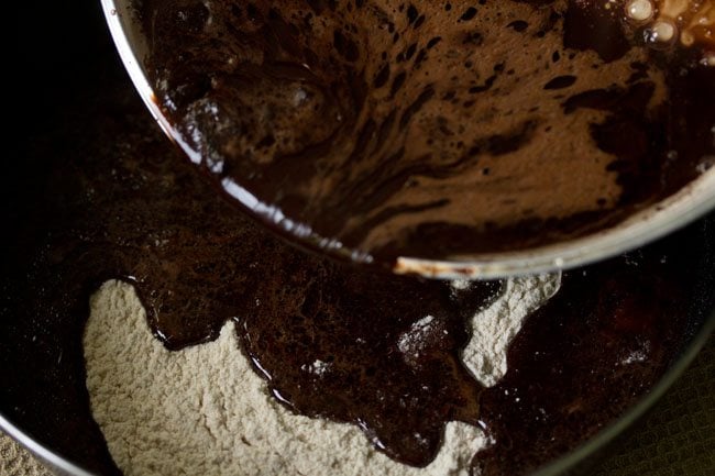 adding cocoa solution to flour mixture for eggless brownie. 