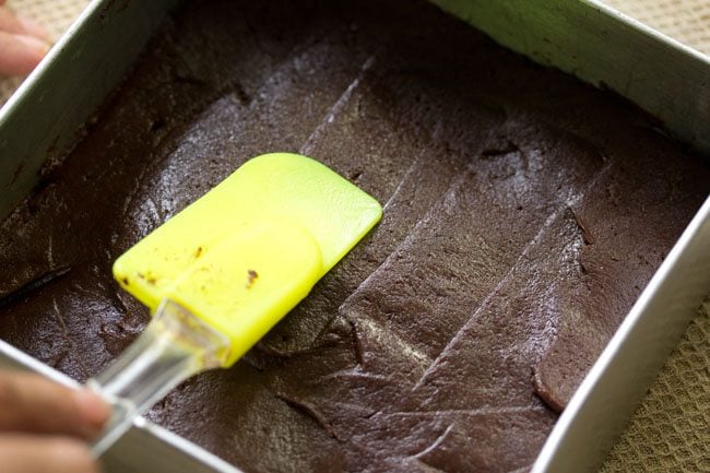 evening the batter in the baking pan using a spatula. 