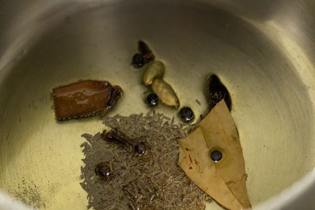 whole spices added in the hot ghee in pressure cooker.