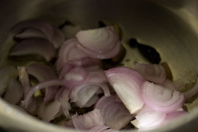 thinly sliced onions added to the hot oil in pressure cooker.
