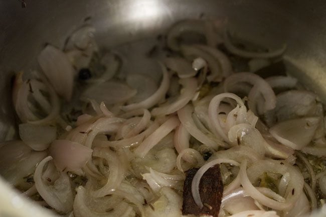 sautéing onions and spices in hot ghee.