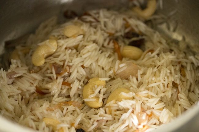mixing rice with other ingredients in the pressure cooker.