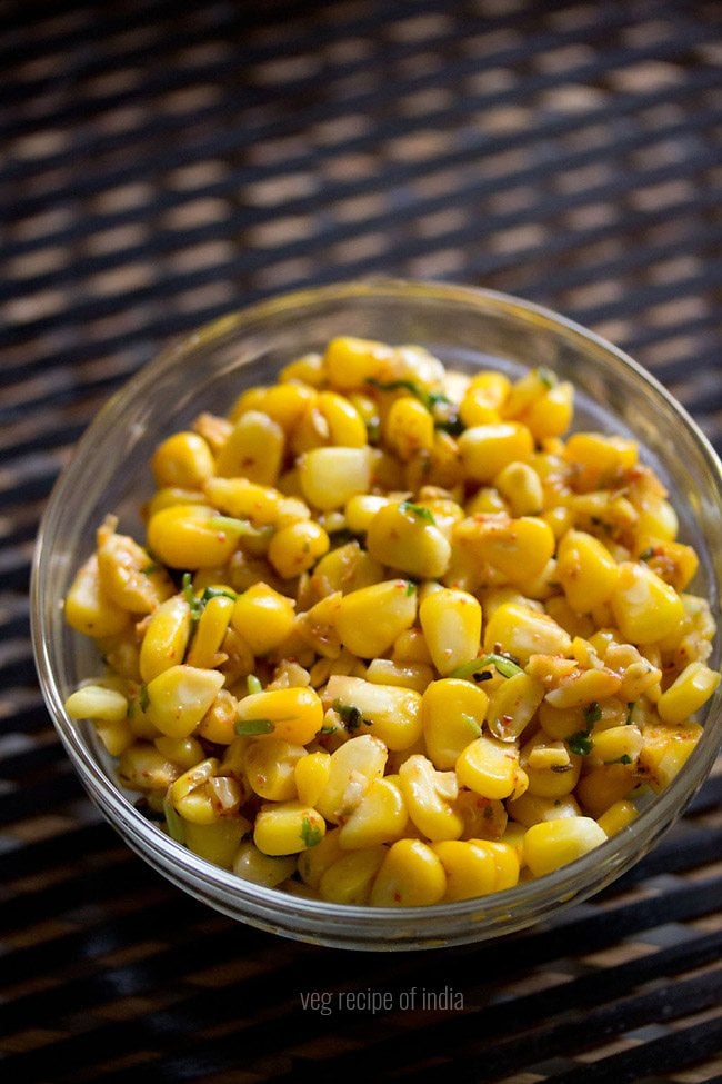 masala corn served in a glass bowl with text layover. 