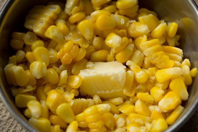 butter added to steamed corn kernels for masala corn recipe. 