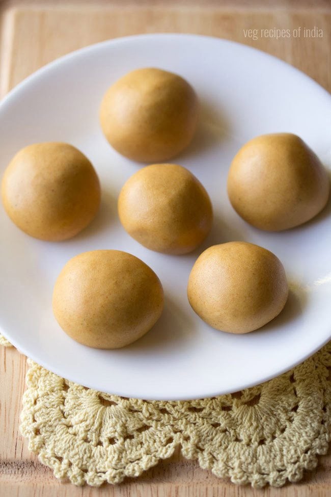 moong dal ladoo served on a white plate with text layover. 