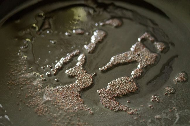 crackling mustard seeds in hot coconut oil in pan. 