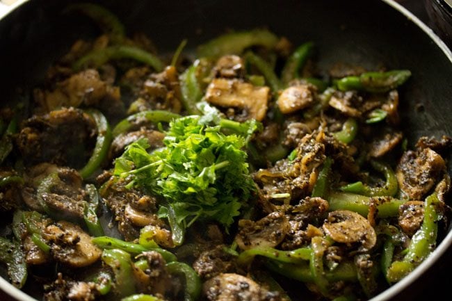 chopped coriander leaves added to cooked mushroom pepper fry. 