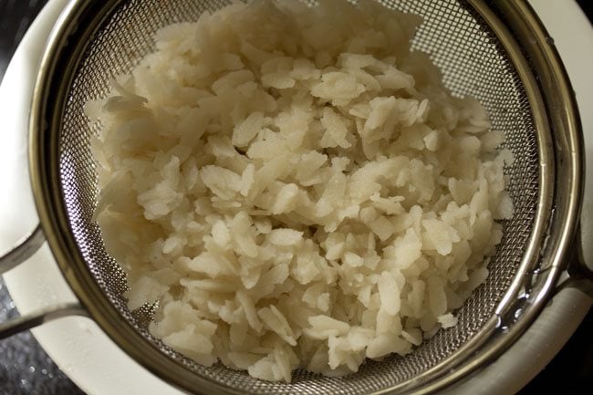 draining poha using a strainer. 