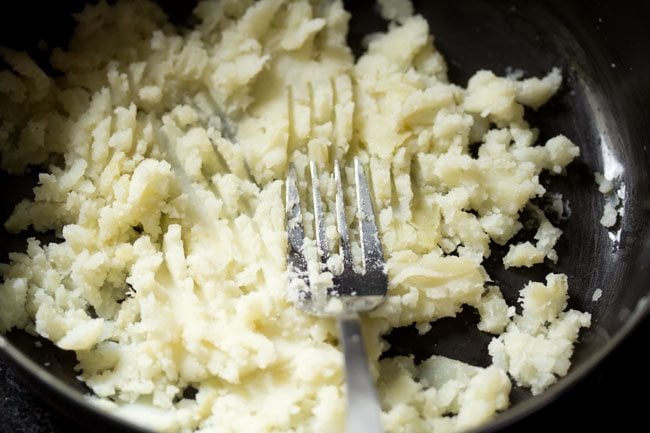 mashing boiled potato with a fork. 