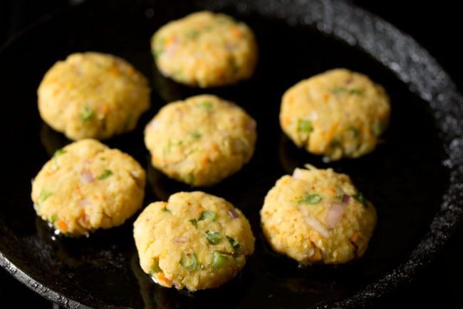 prepared cutlets placed on hot oil on tawa. 