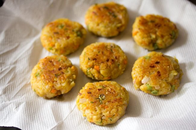 fried poha cutlet placed on kitchen paper towel. 