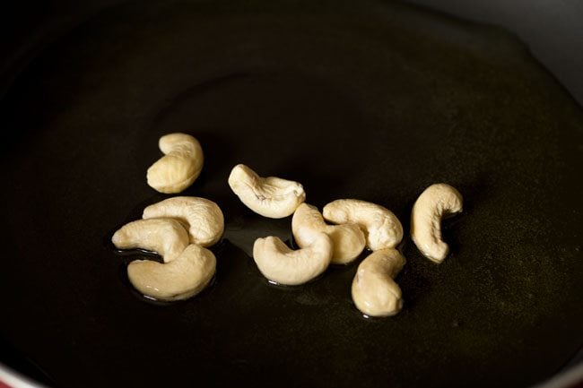 cashews added to melted ghee in pan. 