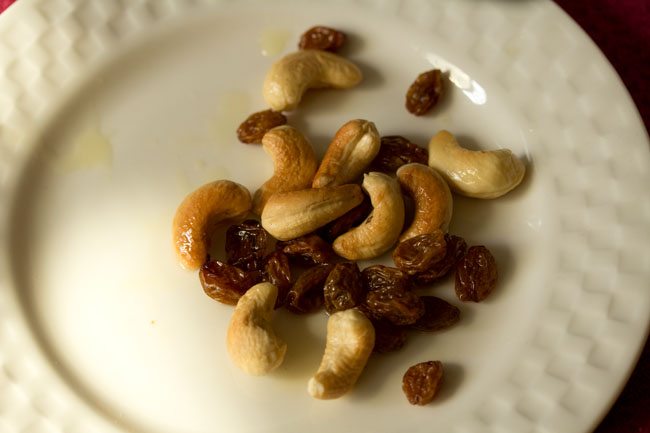 fried cashews and raisins kept on a plate. 