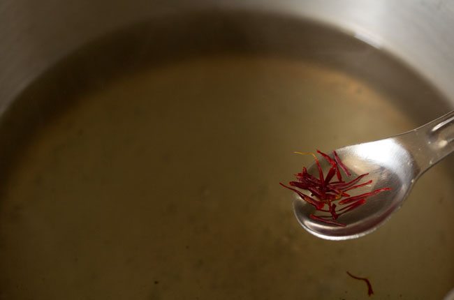 adding saffron strands to the boiling sugar solution. 