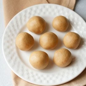 sunnundalu or urad dal laddu served on a white plate.