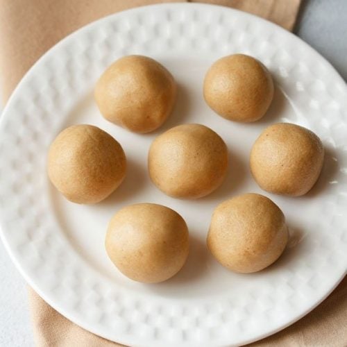 sunnundalu or urad dal laddu served on a white plate.