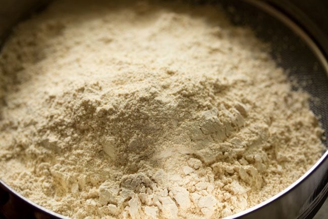 urad dal flour added to a sieve. 