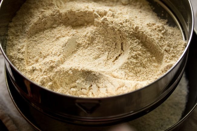 sifting urad dal flour on a plate. 