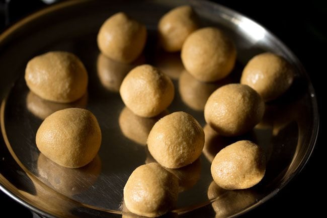 eleven urad dal laddu on a steel plate. 