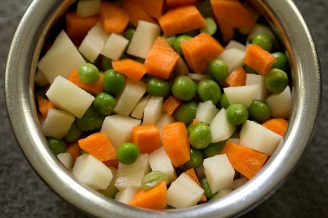 cubed potatoes, carrots and green peas in a bowl for veg puff.