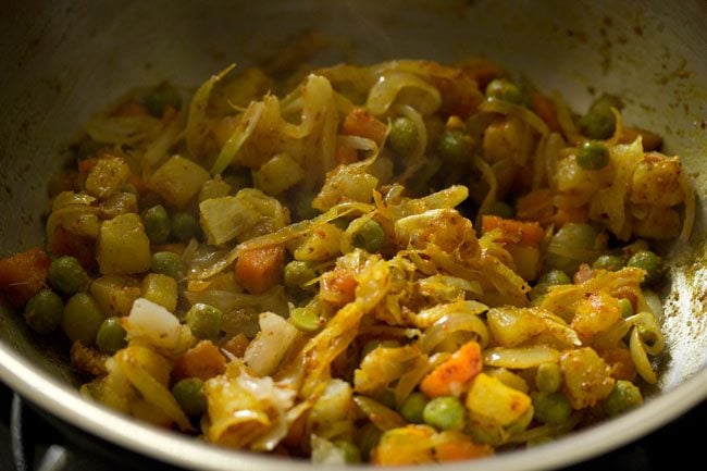 mixing the spices with the mixed vegetables. 