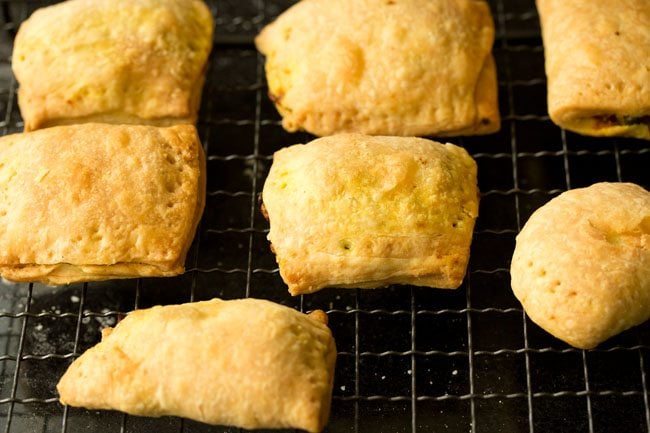 baked veg puffs placed on a wire rack for cooling. 