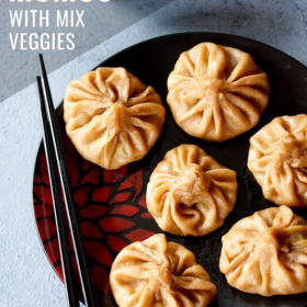 wheat momos arranged on a black plate with black chopsticks kept on the left side with text layovers.