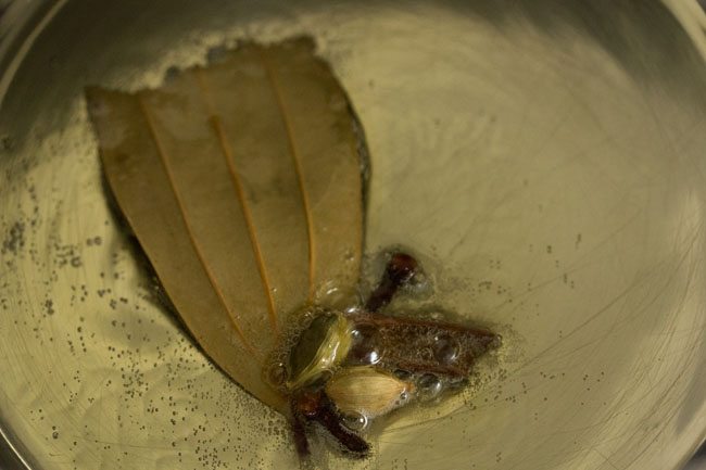 spices and herbs added to pan with oil