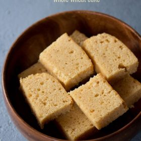 slices of wheat cake kept neatly in a wooden bowl on a light grayish blue board