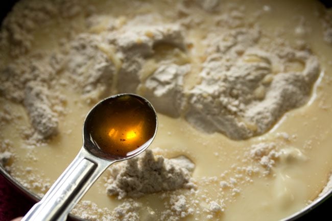 vanilla extract being added with a measuring spoon