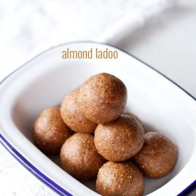 badam ladoo served in a blue rimmed rectangular shallow plate with text layover.