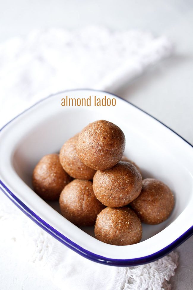 badam ladoo served in a blue rimmed rectangular shallow plate with text layover.