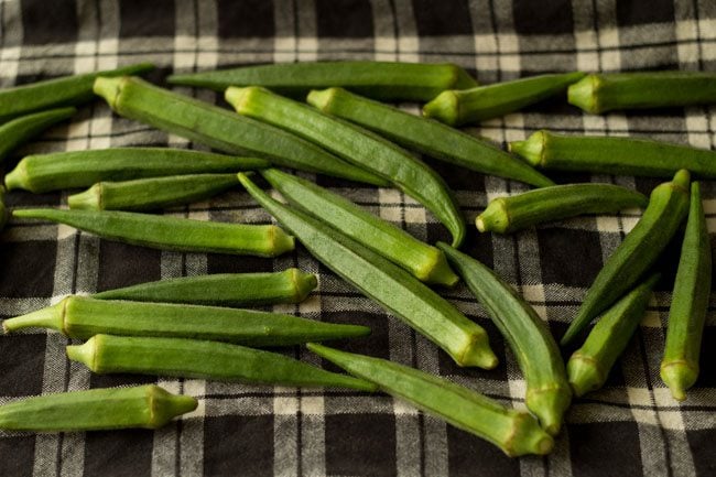 drying rinsed okra on a kitchen towel for bendakaya curry. 